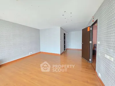 Spacious empty room with wooden flooring and patterned wallpaper, ideal for customization.