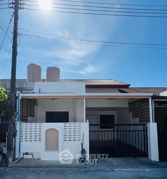 Charming single-story home with modern facade and spacious driveway under clear blue sky.