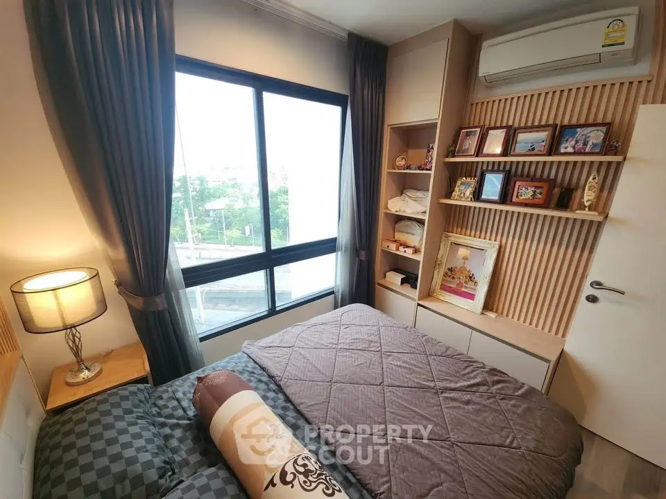 Cozy bedroom with large window and stylish decor in modern apartment