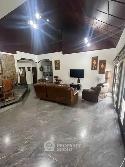Spacious living room with modern decor and leather sofas in a luxurious home.