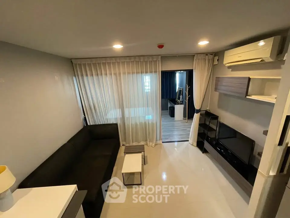 Modern living room with sleek furniture and large windows in a stylish apartment.