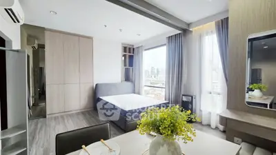 Modern bedroom with city view, stylish decor, and natural light