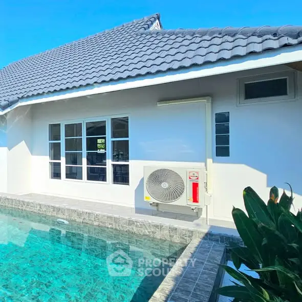 Charming home exterior with a sparkling pool and modern roof design, perfect for relaxation and entertaining.