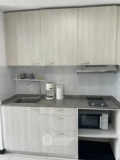 Modern kitchen with sleek cabinetry, granite countertops, and built-in appliances.