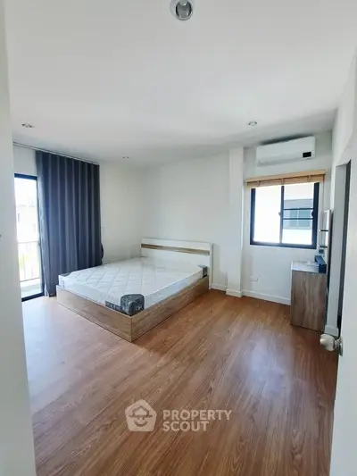 Spacious bedroom with modern design and large window for natural light.