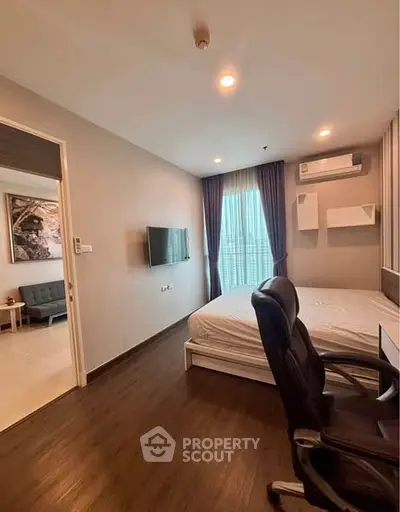 Modern bedroom with sleek design, featuring a wall-mounted TV and stylish furnishings.