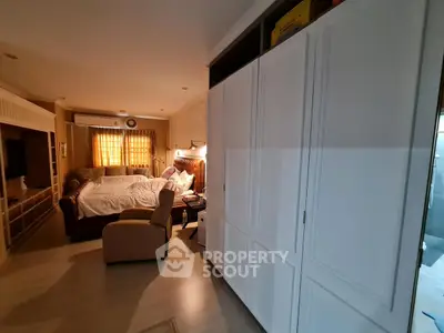 Cozy bedroom with elegant built-in wardrobe and comfortable seating area.