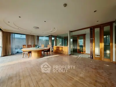 Spacious open living room with wooden flooring and elegant dining area