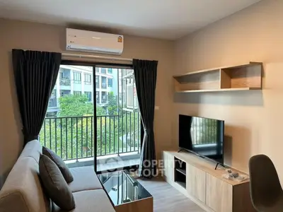 Modern living room with balcony view, featuring sleek furniture and natural light.