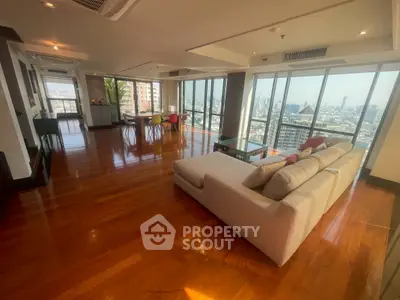 Spacious modern living room with panoramic city views and elegant wooden flooring.