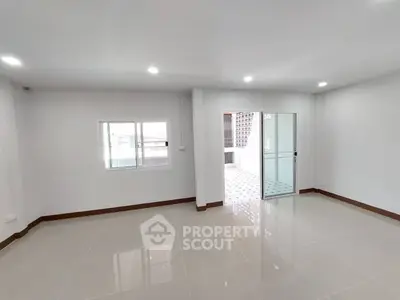 Spacious empty room with glossy tiled floor and sliding glass door