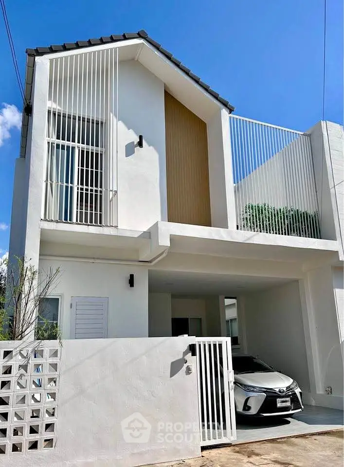 Modern white two-story house with carport and sleek architectural design.