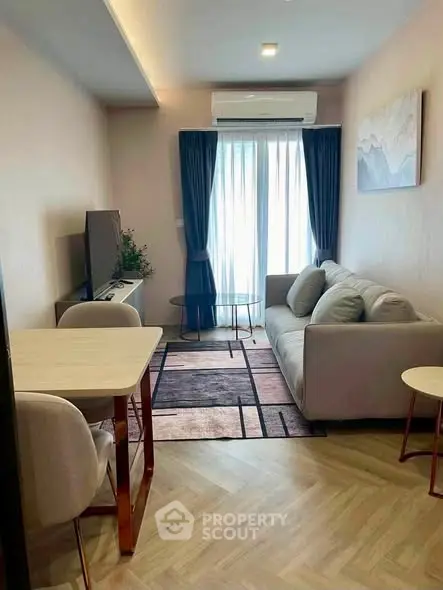 Modern living room with cozy sofa, stylish decor, and natural light from large window.