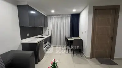 Modern open-layout kitchen with sleek cabinetry and dining area in stylish apartment.
