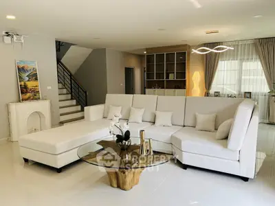 Spacious modern living room with elegant white sectional sofa and unique glass coffee table.