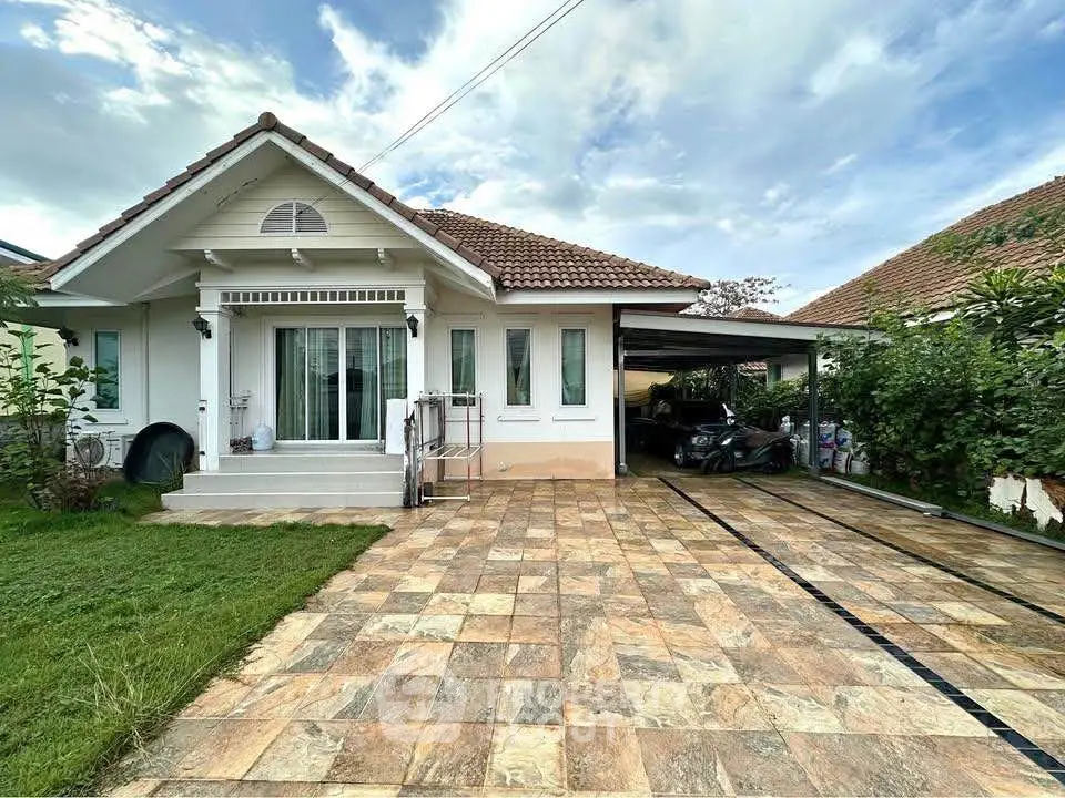 Charming single-story home with spacious driveway and lush greenery, perfect for family living.