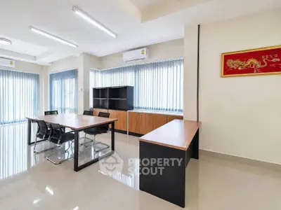 Spacious modern office space with sleek furniture and large windows for natural light.
