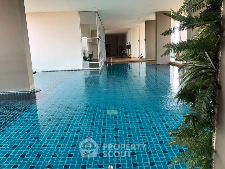 Luxurious indoor swimming pool with modern design and lush greenery, perfect for relaxation and leisure.