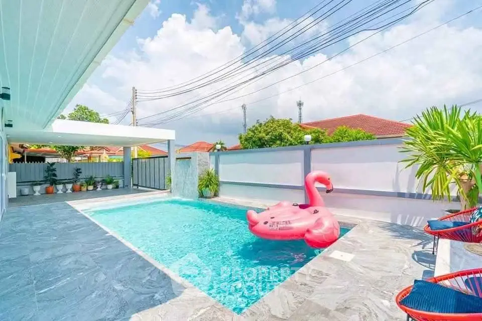 Stunning outdoor pool area with modern design and vibrant pink flamingo float.