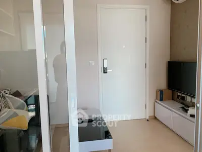 Modern living room with sleek furniture and TV setup, showcasing minimalist design and cozy ambiance.