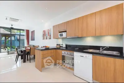 Modern kitchen with sleek wooden cabinets and open layout in a bright, spacious home.