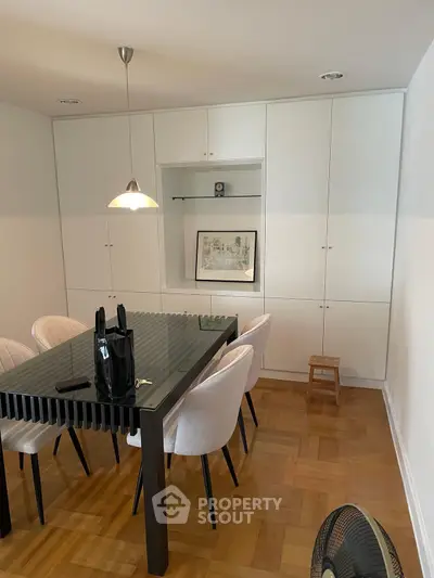 Elegant dining room with modern glass table and built-in storage cabinets