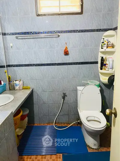 Cozy bathroom with modern amenities and tiled walls, featuring a practical layout.