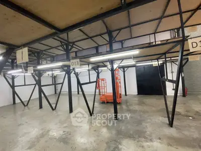 Spacious industrial storage unit with metal shelving and concrete flooring, ideal for warehouse needs.