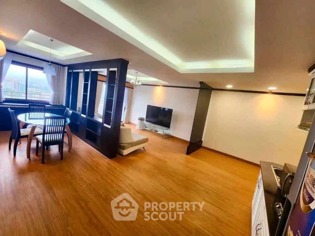 Spacious modern living room with wooden flooring and large windows offering a stunning view.