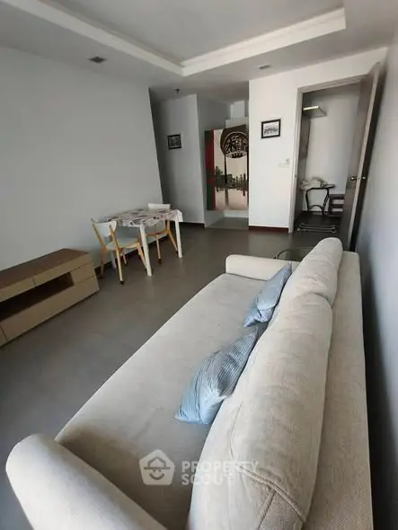 Spacious living room with modern decor and dining area in open layout apartment.
