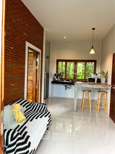Charming open-layout kitchen with breakfast bar and cozy living area, featuring modern decor and natural light.