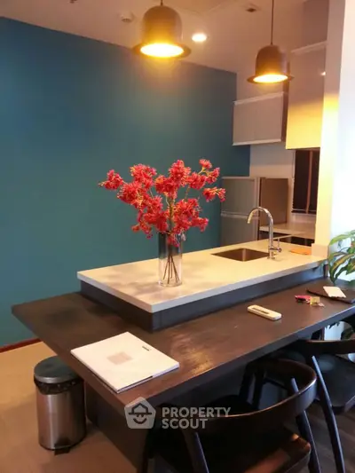 Modern kitchen with stylish island and vibrant decor in a contemporary apartment.