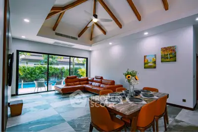 Luxurious living room with pool view, high ceilings, and elegant dining area in modern home.