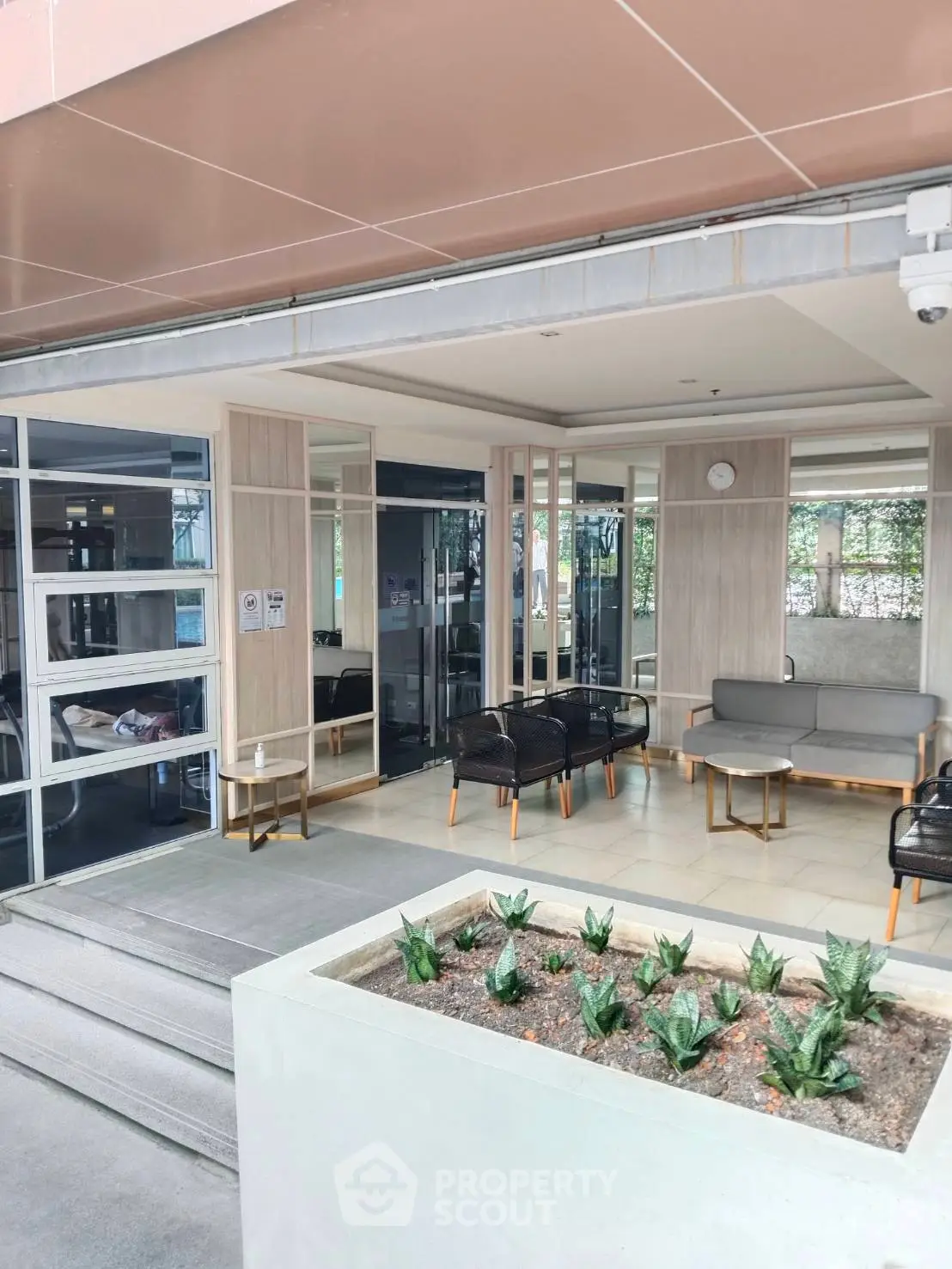Modern building entrance with stylish seating area and planters