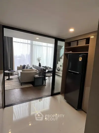 Modern open-plan living room with stylish decor and large windows for natural light.