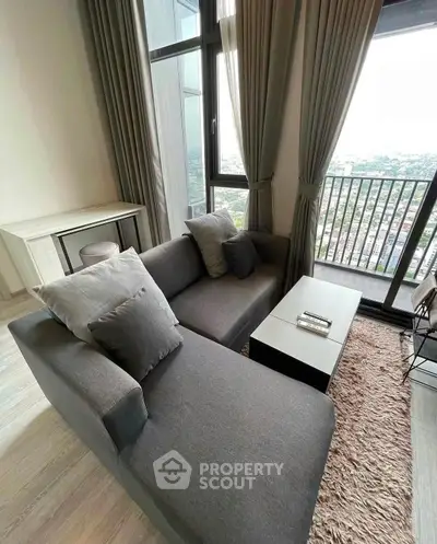 Stylish living room with modern sofa and city view balcony in high-rise apartment.