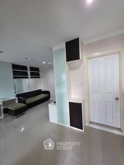 Modern living room with sleek furniture and glossy tiled flooring