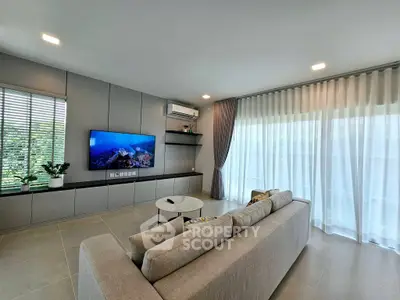 Modern living room with sleek design, large sofa, and wall-mounted TV, perfect for relaxation.