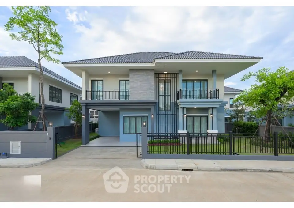 Modern two-story house with spacious driveway and lush greenery