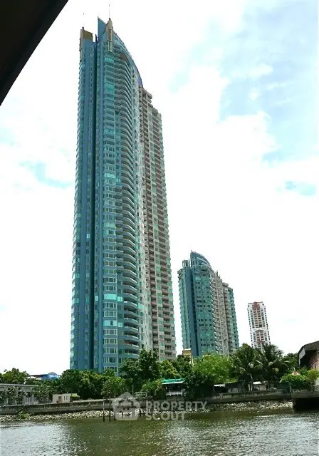 Stunning high-rise residential towers with riverfront view and lush greenery.
