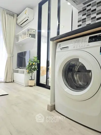 Modern living room with washing machine, air conditioning, and stylish decor in a bright apartment.