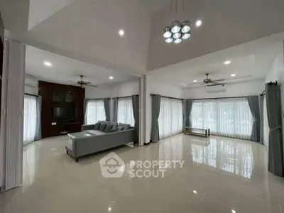 Spacious modern living room with elegant lighting and large windows for natural light.