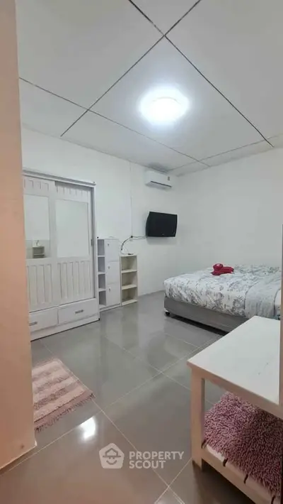 Cozy bedroom with modern furnishings and wall-mounted TV