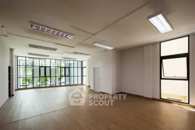 Spacious modern living room with large windows and wooden flooring
