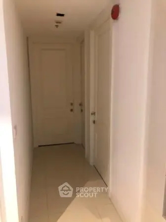 Bright hallway with multiple doors in modern apartment building.
