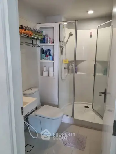 Modern bathroom with glass shower and sleek fixtures in a contemporary apartment.