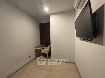 Minimalist study room with desk, chair, and wall-mounted TV in modern apartment.