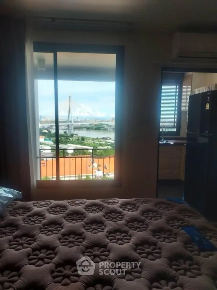 Cozy bedroom with stunning river view and balcony access in modern apartment.