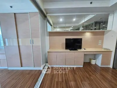 Modern living room with sleek wooden flooring and built-in TV unit