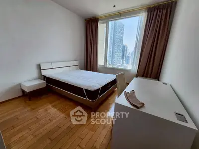 Spacious bedroom with city view, hardwood floors, and modern furnishings.